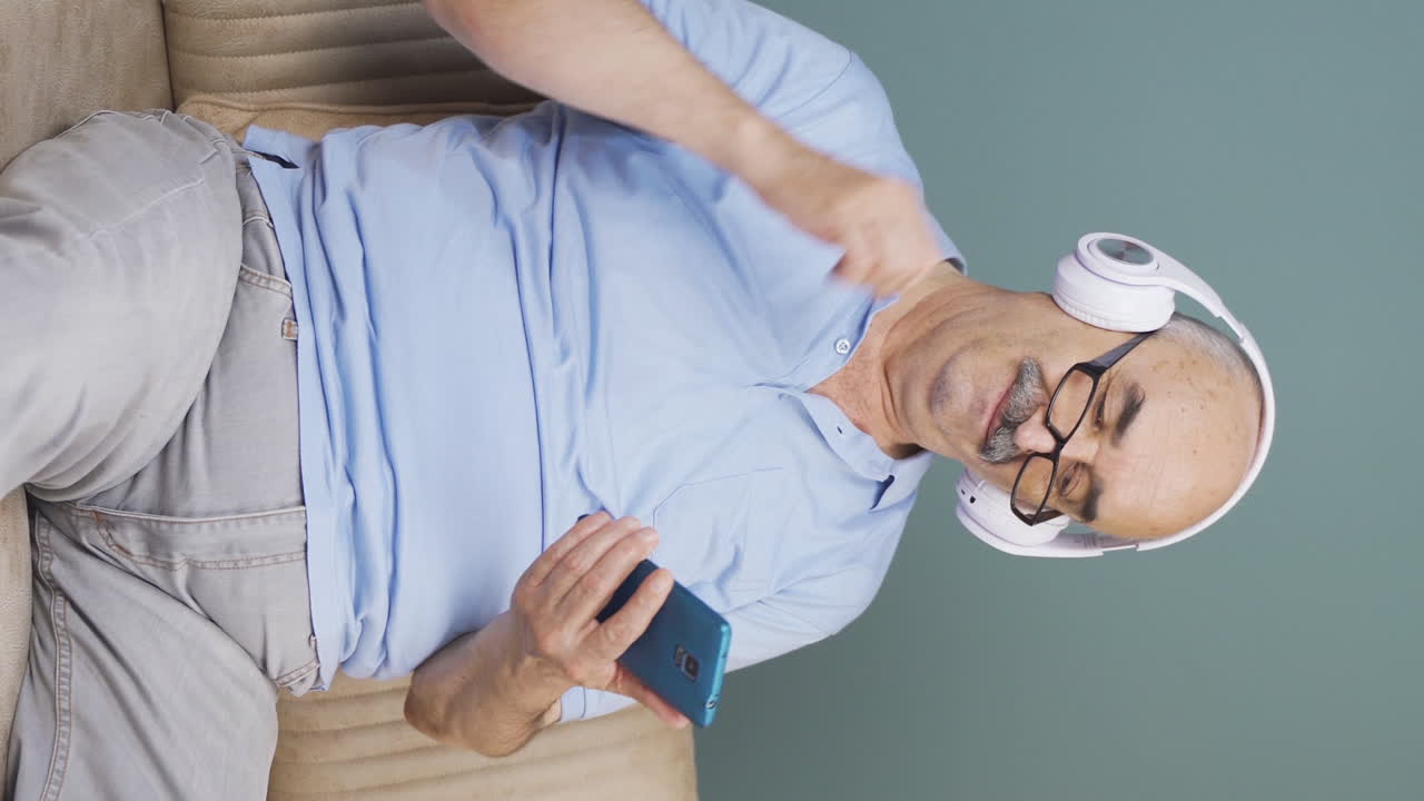 Vertical video of Old man listening to music and relaxing. Relax and peaceful.