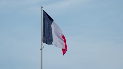 En-Cámara-Lenta,-La-Bandera-Francesa-Ondea-Elegantemente-Con-La-Brisa.