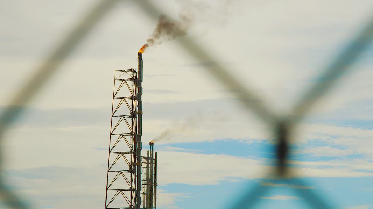 curacao의 산업 굴뚝에서 연기와 불이 나는 것을 보는 것 - 와이드 샷