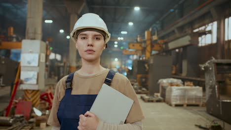 portrait of female worker holding digital tablet in industrial factory