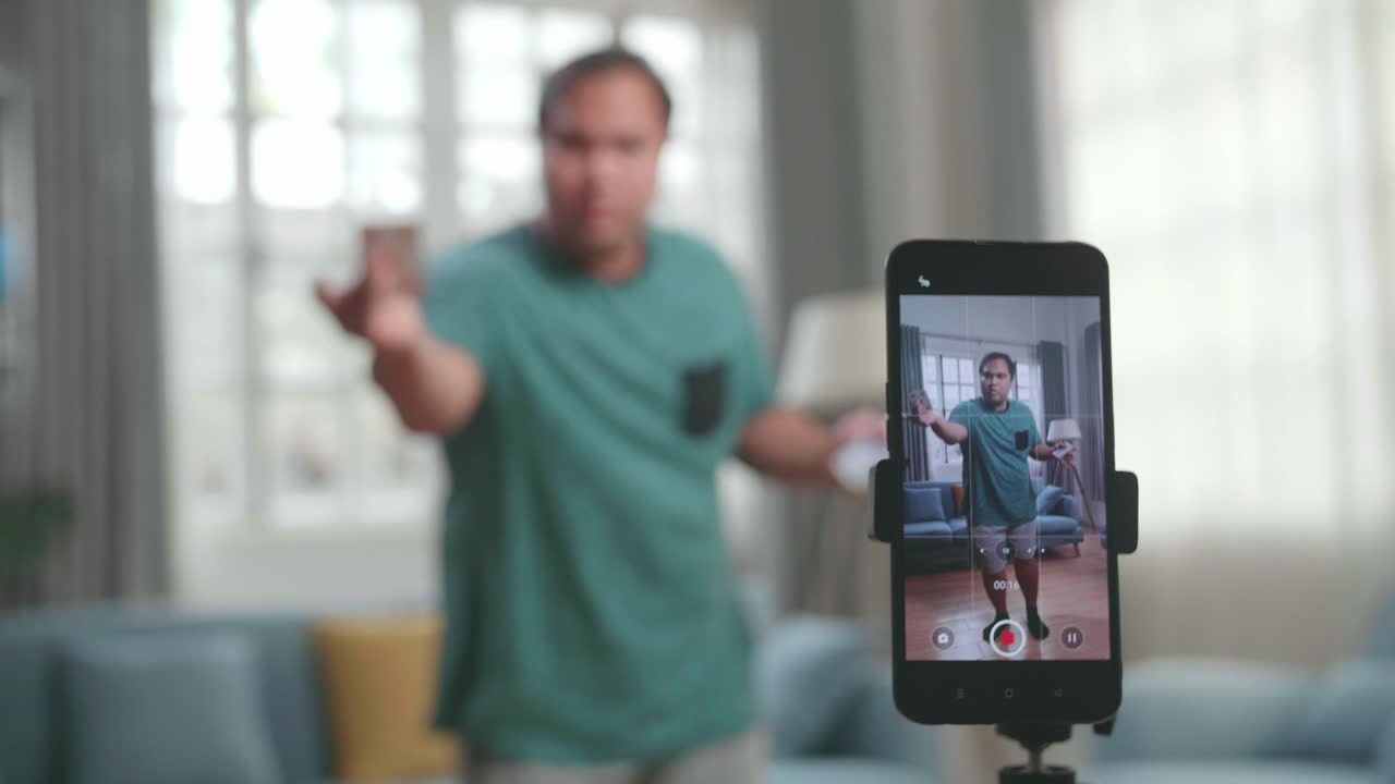 Blogger asiatico registra contenuti video per i social network e mostra il focus sulla fotocamera dello smartphone, primo piano, mago con carte da gioco.