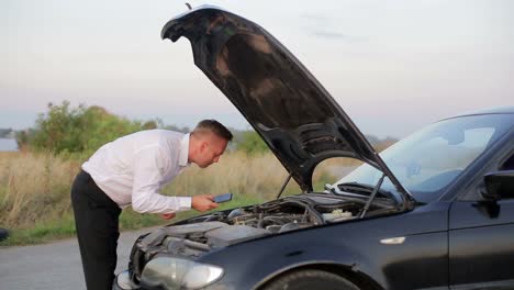 businessman with the problem of checking the car under the hood businessman with the problem of checking the car under the hood car crash