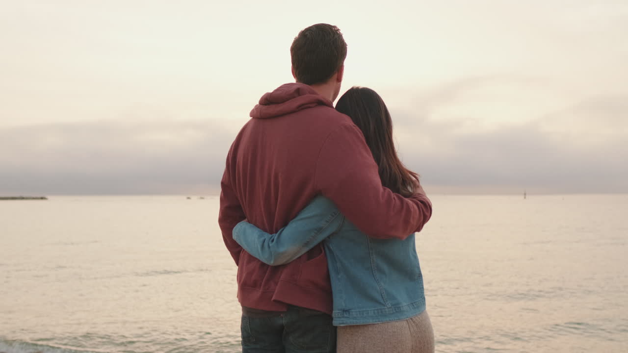 Couple Embracing on a Beach at Sunset