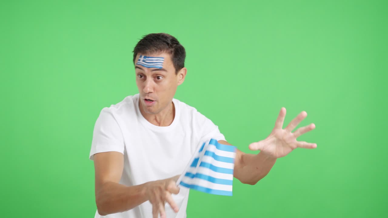 Man cheering for Greece waving a national flag looking away