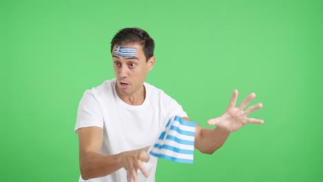 man cheering for greece waving a national flag looking away