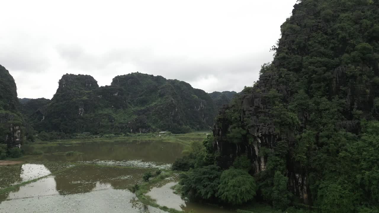 Cánh đồng lúa nhìn từ trên cao giữa núi non xanh tươi ở Châu Á vào một ngày nhiều mây