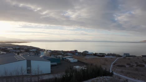 vista aérea que muestra numerosas casas construidas a través de un vasto mar bajo un cielo nublado y rayos de sol que hacen que todo el pintoresco mágico