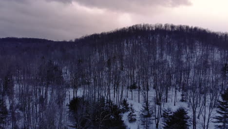 Barren-trees-in-the-snowy-mountains-of-Vermont-during-colorful-sunset