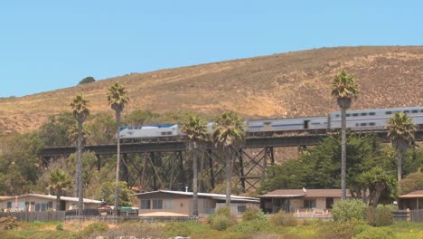 an amtrak passenger train moves across a bridge in california