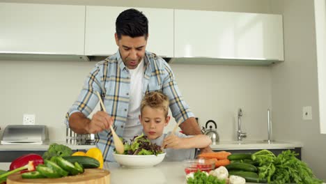 Padre-Mostrando-A-Su-Hijo-Cómo-Preparar-Una-Ensalada