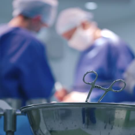 medical tools on blur surgery background. bowl with sterile scissors in the operating room. close-up. instruments for surgical procedure.