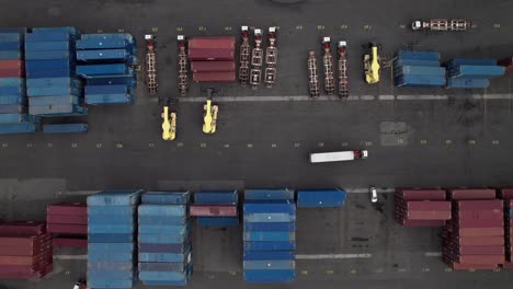 satisfying geometric overhead of a transport truck driving among intermodal containers in an industrial shipping yard