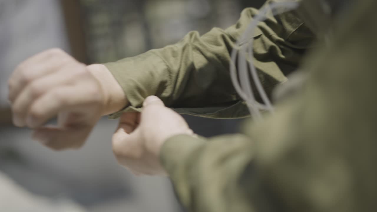 Close up of Israeli soldier's hand fastening the button on his shirt sleeve