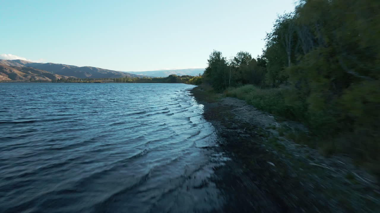 fotografía aérea de vuelo bajo sobre un profundo río azul clutha en la región de otago, nueva zelanda