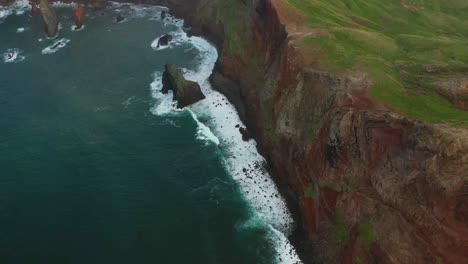 incline hacia arriba el disparo de un dron sobre un acantilado de una península en madeira durante la puesta de sol