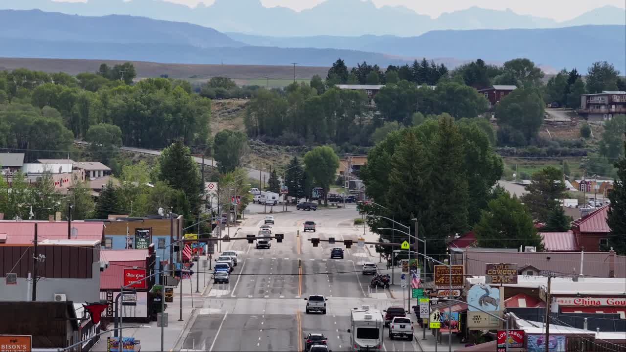 A small-town street in pinedale, wyoming, panning up to large mountains looming in the distance