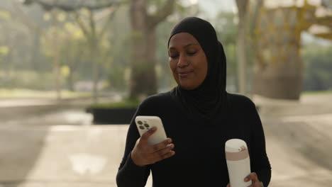 woman in hijab using phone outdoors