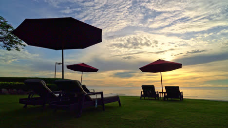 sombrilla con silla con fondo de playa y amanecer en la mañana - concepto de vacaciones y vacaciones