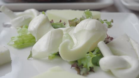 assorted cheeses with salad on a plate