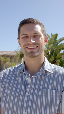 vertical video of portrait of happy caucasian man at beach house