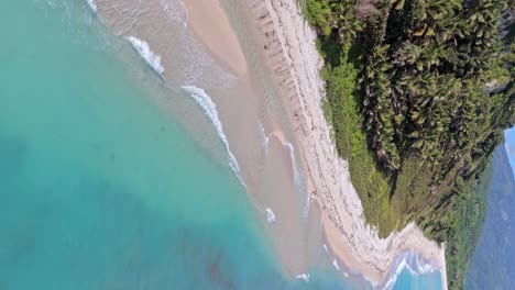 Vista-Vertical-De-Las-Olas-Del-Mar-Azul-Turquesa-En-La-Costa-De-La-Playa-De-Los-Patos-En-Verano-En-Barahona,-República-Dominicana