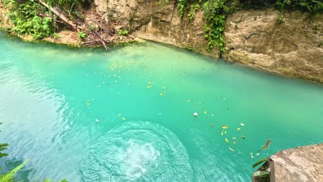 a woman jumps from a 10meter platform while canyoneering at kawasan falls in cebu, philippines