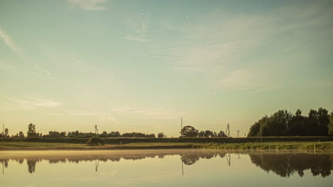 Static-shot-of-traffic-movement-along-highway-beside-a-lake-with-the-view-of-sunset-int-he-background-in-timelapse