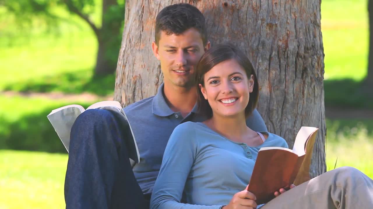pareja joven leyendo al aire libre