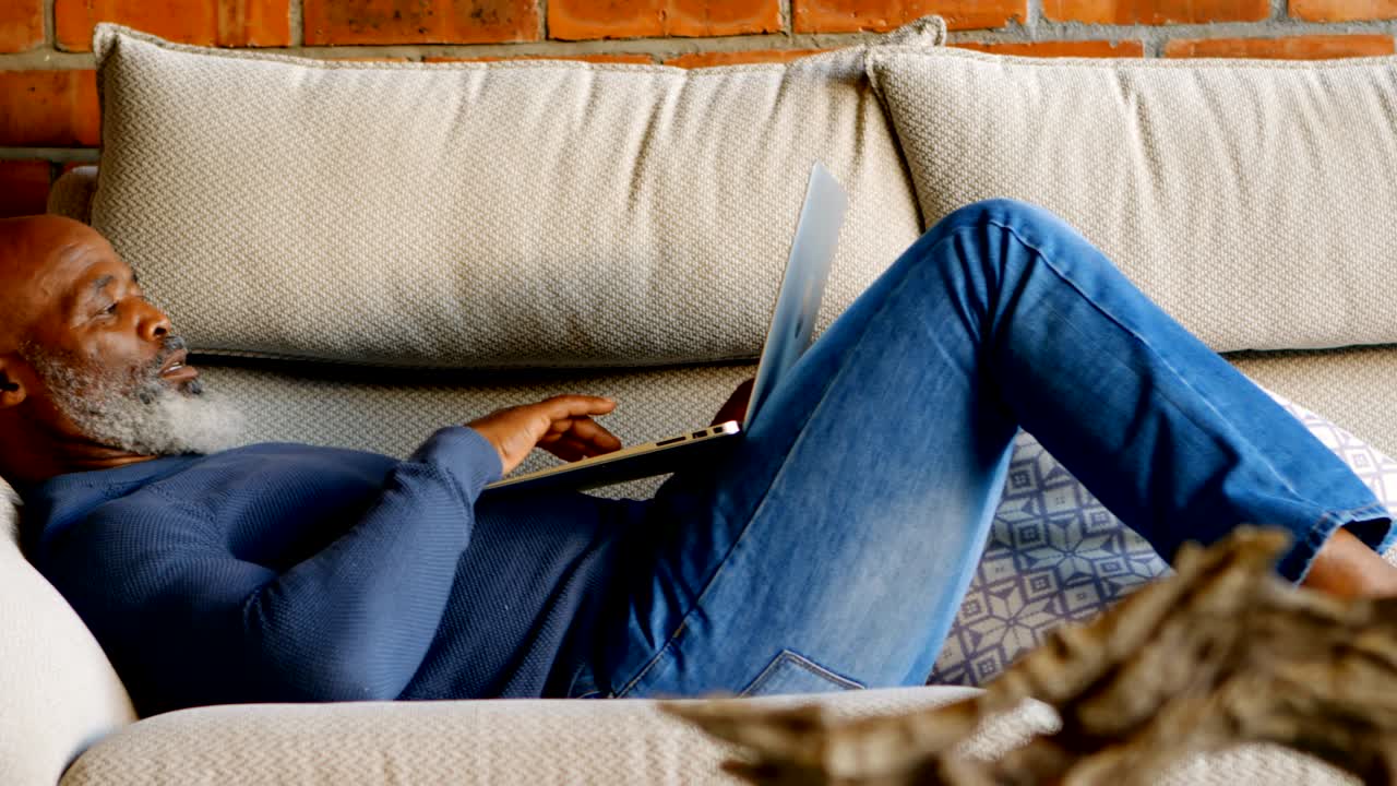 hombre mayor usando portátil en la sala de estar 4k
