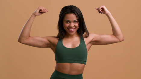 mujer flexionando los músculos en traje de entrenamiento