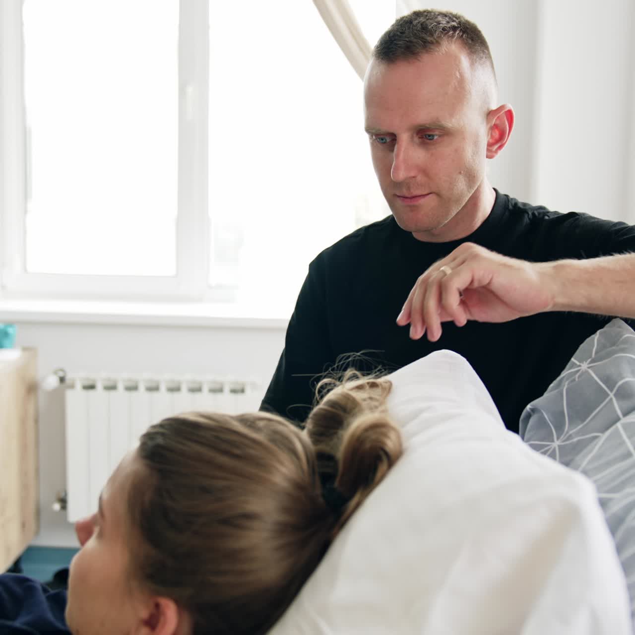 Woman is prepared for giving birth to a baby in hospital. Concerned husband stands beside the wife