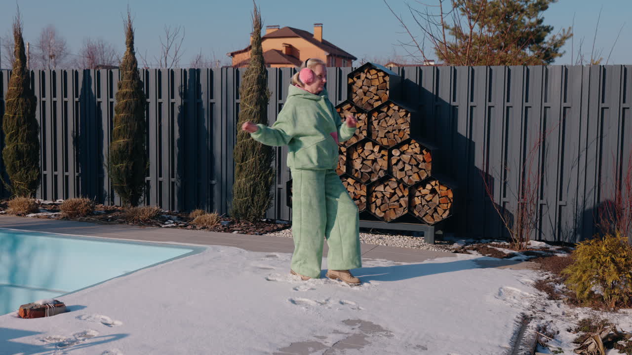 mujer bailando en la nieve junto a la piscina