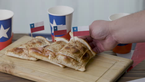 fiestas patrias chile poniendo una empanada y banderas chilenas