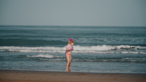 바다의 파도와 놀고 있는 행복한 맨발 아이