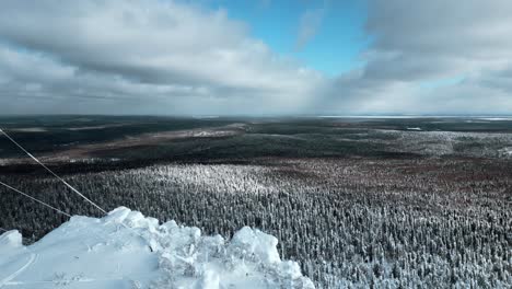 snowy mountain peak with aerial view of winter forest