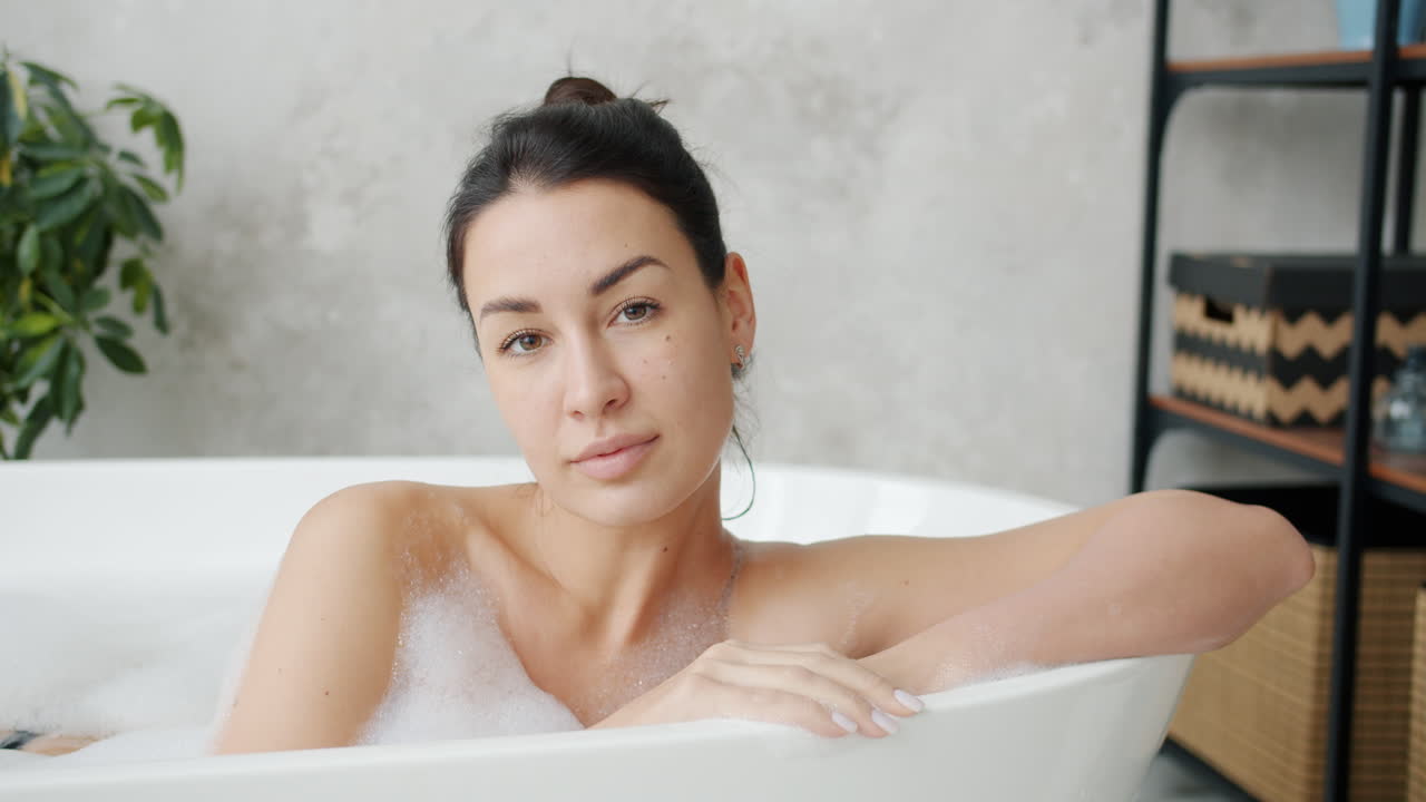 거품이 있는 욕조에서 휴식을 취하는 여자