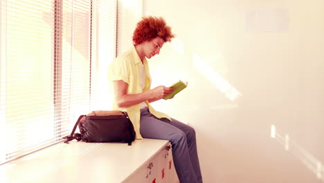 Happy-student-sitting-on-lockers-