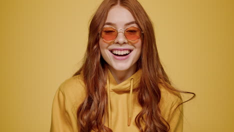 euphoric woman making hand gesture indoors. girl acting on orange background