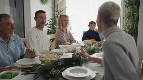 big caucasian family sitting at the christmas table and talking together.