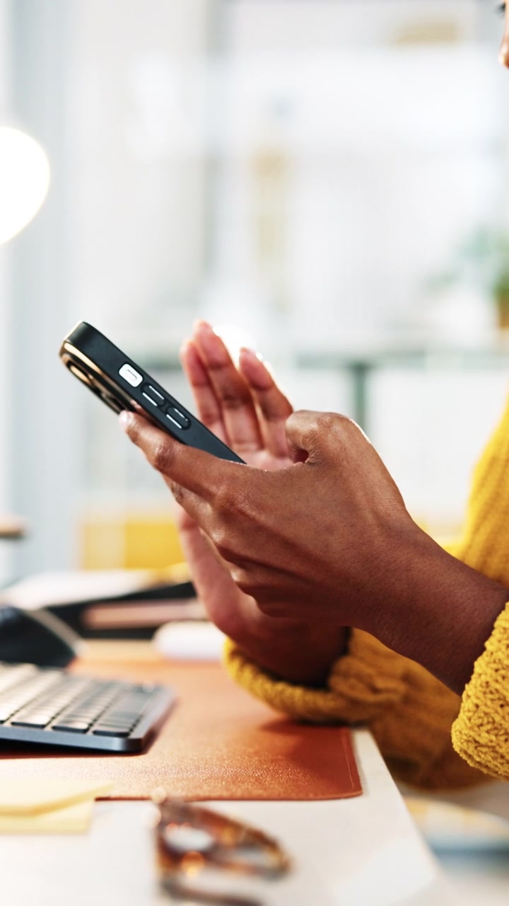 Persona che usa lo smartphone alla scrivania in un ufficio moderno