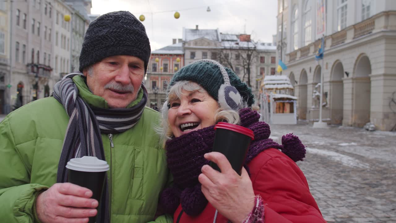 수석 부인 남편 관광객들이 컵으로 술을 마시고 시내 중심가에서 뜨거운 음료 차를 즐기고 있습니다.
