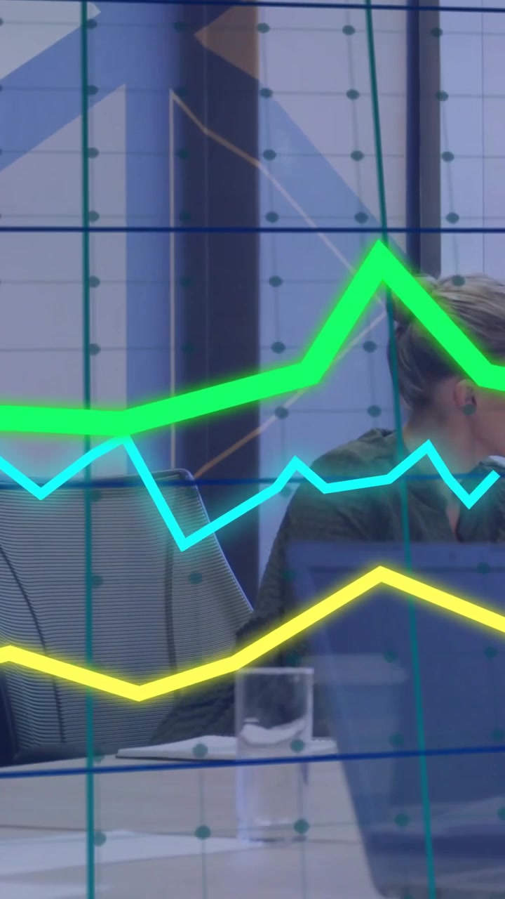 Donna che si gira e ascolta in un contesto aziendale, con un aggiornamento dati che anima grafici attraverso l'inquadratura, monitorando le vendite.