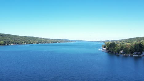 aerial view from drone of keuka lake in the finger lakes looking north with speed boat pulling into view