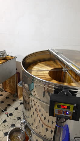 beekeeper's room for storing wooden hives and extracting honey. centrifuge mechanism working rotating frames to collect honey. vertical video