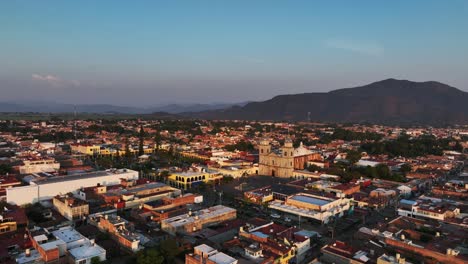 volando hacia la plaza del centro de la ciudad con la iglesia de tuxpan en jalisco, méxico