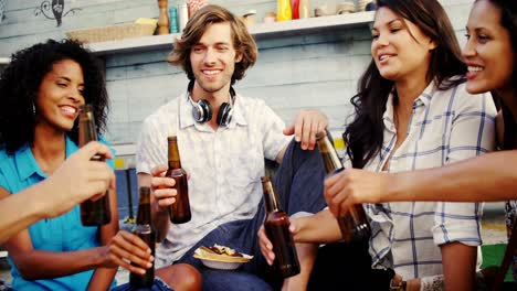 grupo de amigos brindando botellas de cerveza