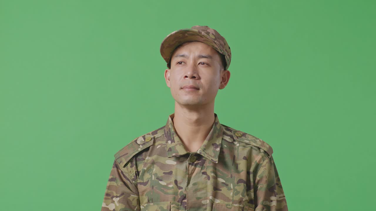 Close Up Of Asian Man Soldier Looking Around While Standing In The Green Screen Background Studio