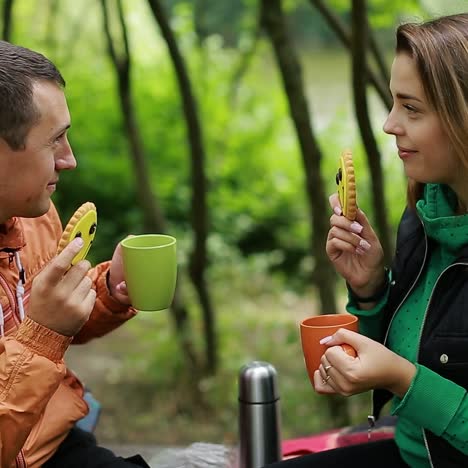 pareja en la naturaleza bebiendo té