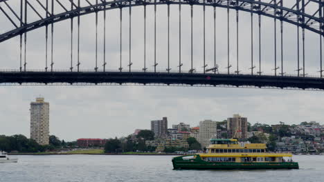 A-passenger-ferry-passes-in-front-of-the-Sydney-Harbour-Bridge,-Australia