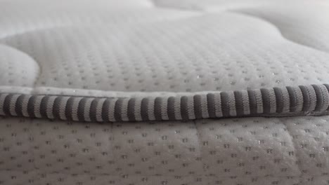 close-up of a white mattress with gray striped stitching